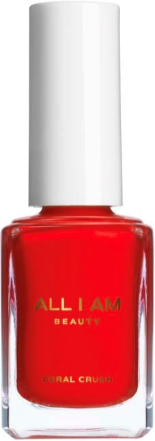 A bright red nail polish bottle with a white cap, labeled "ALL I AM BEAUTY" and "CORAL CRUSH."