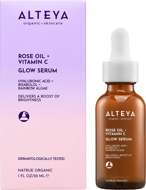 A brown bottle with a white dropper, next to a pink box with brand and product details, including rose oil and vitamin C.