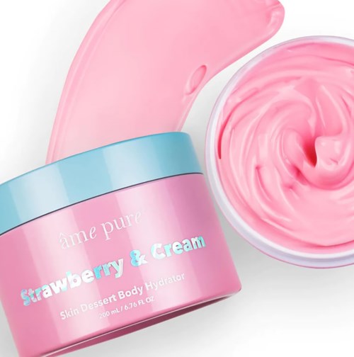 Ein rosa Behälter und eine Schüssel mit rosa Creme, Beschriftung 'Strawberry & Cream' für Hauthydration. Die Creme ist geschwungen und glatt.