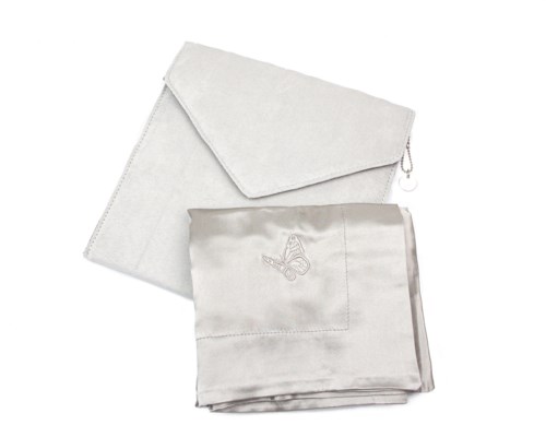 Ein weißes Geschenkeset enthält eine Tasche mit Schmetterlingsstickerei und ein passendes Tuch oder Handtuch.