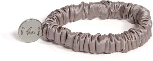Ein helllila Satin-Haarband mit rundem silbernen Anhänger auf weißem Hintergrund.