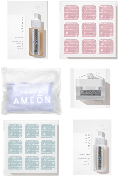 Hautpflegeprodukte mit einer Flasche, einer Packung und zwei Blätter mit rosa und blauen Etiketten oder Aufklebern. Alle Gegenstände sind ordentlich angeordnet.