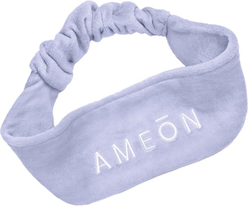 Ein hellvioletter Stoffohrband im Scrunchie-Stil mit der Aufschrift 'AMEÓN'.