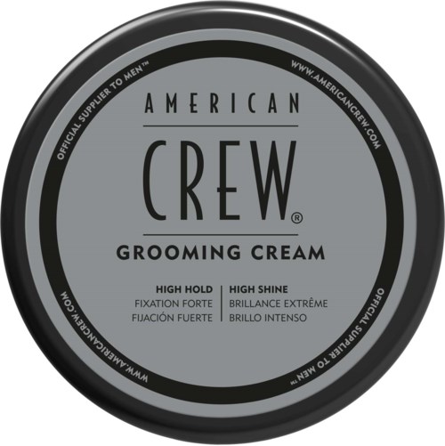 Et rundt lokk med teksten "American Crew Grooming Cream" og beskrivelser av høy holdeevne og høy glans.