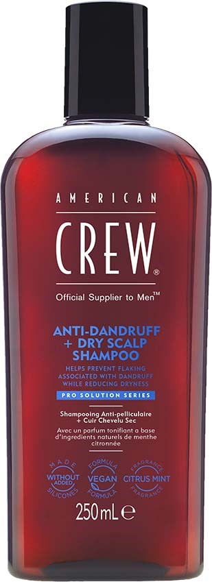 Een rode fles American Crew anti-roos en droge hoofdhuid shampoo met zwarte dop. Tekst beschrijft productvoordelen.