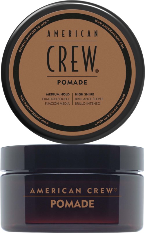 A round container with a brown lid and black body labeled 'American Crew Pomade.'