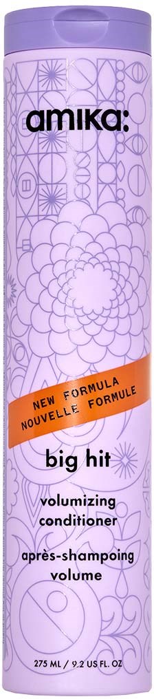 Pitkä violetti Amika Big Hit -volyymisvaha, jossa on koristeellisia kuvioita ja oranssi etiketti, jossa lukee 'New Formula'.