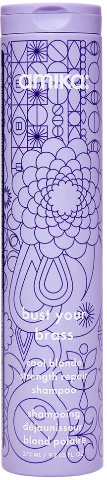 Violetti pullo, jossa monimutkaisia kukka- ja geometrioita, merkinnällä 'emika' ja 'bust your brass' shampoo.