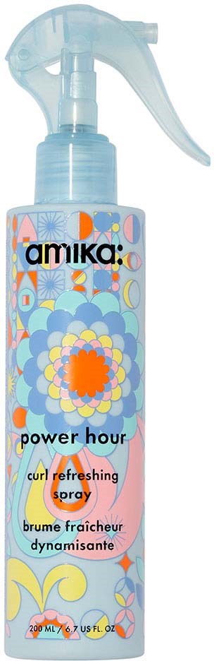 A spray bottle with colorful, floral and abstract design, labeled 'amika power hour curl refreshing spray'.