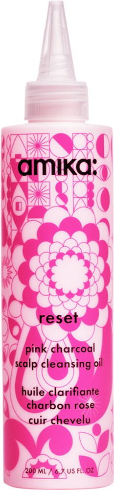 A pink and white patterned bottle with a pointed cap, labeled 'amika: reset' for scalp cleansing oil.