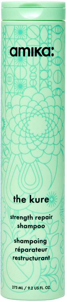 A green bottle labeled 'amika: the kure' for strength repair shampoo with decorative patterns.