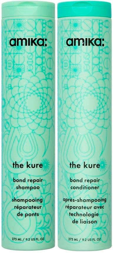 Two teal bottles of Amika's The Kure bond repair shampoo, decorated with floral and geometric patterns, stand side by side.