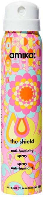 Kolorowa butelka z sprayem z kwiatowym wzorem i napisami "amika: the shield anti-humidity spray".
