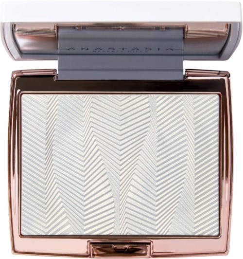 Een make-up compact met wit en goud gevlekt poeder erin, en de deksel wordt erboven gespiegeld.