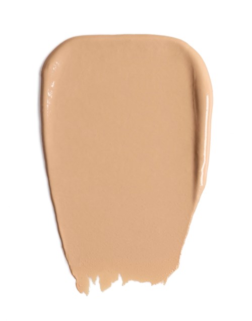Ein beige flüssiger Make-up-Test auf weißem Hintergrund.