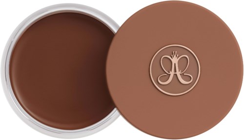 A round container with a brown, creamy inside and a matching lid with a decorative logo.
