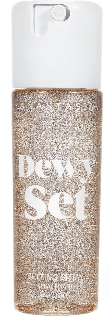 Eine Sprühflasche mit klarem Deckel und glitzernder, goldfarbener Flüssigkeit im Inneren. Marke ist Anastasia, Beschriftung 'Dewy Set.'