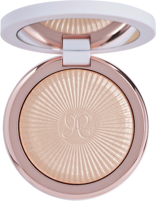 Een ronde make-up compact met glanzende, lichte poeder erin en een witte deksel die open is.