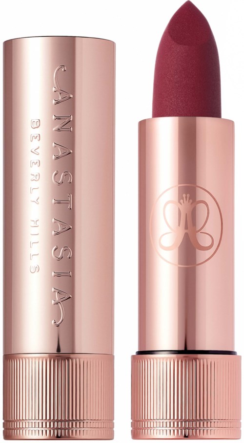 Een roségouden lippenstiftstaaf met logo en donkerrode lipstick.