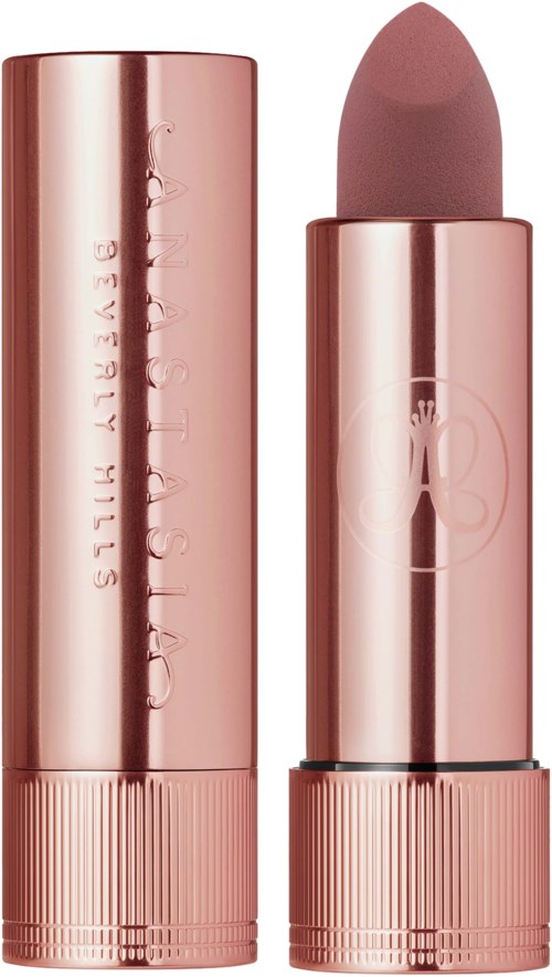 A pink lipstick in a shiny tube with the top off, showing the balm inside. The tube has text and a logo.