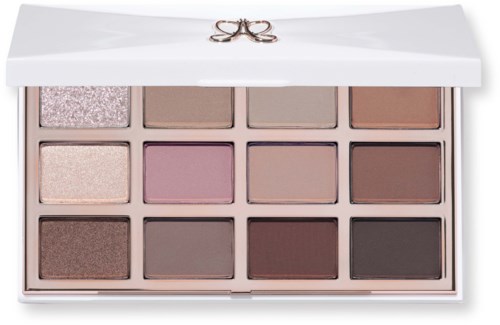 Makeup palette with twelve neutral and pink shades in a white case with a bow on the lid.