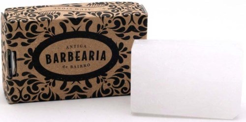 A brown and black soap package with curly patterns and a white soap bar outside.