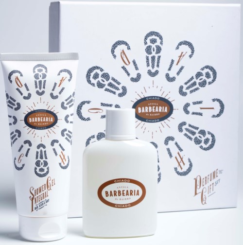 A shaving set with a cream tube, a small bottle, and a decorative box with barber-themed graphics and logo.