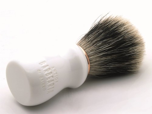 A white shaving brush with black and white bristles on a white background.