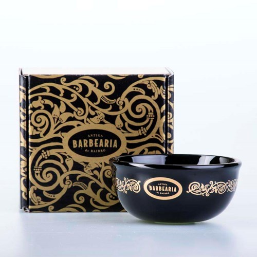 A black bowl with gold decorations and a matching box with intricate gold patterns and the label 'Antiga Barbearia'.