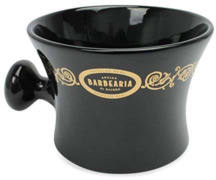 Black ceramic cup with gold decorative details and a handle, labeled 'Antiga Barbearia do Bairro'.