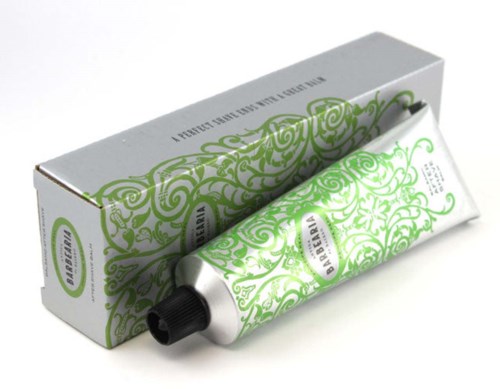 Eine Tube mit grüner und weißer Creme und verzierenden Wirbelmustern, neben einer passenden Verpackung.