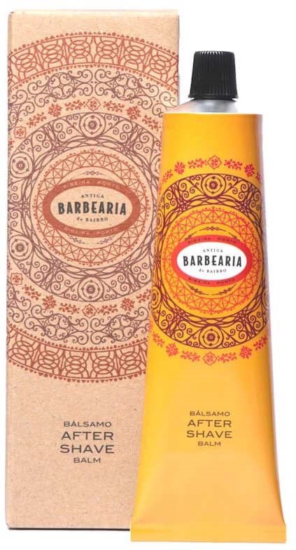 Keltainen after shave -voideputeli, jossa on punaisia ja oransseja koristeellisia kuvioita, vieressä sama kuvioitu laatikko.