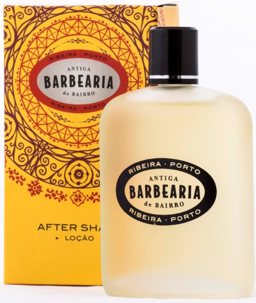 Eine gelbe und schwarze Flasche mit After-Shave-Lotion und passender dekorativer Box, beschriftet mit 'Barbearia' aus Porto, Portugal.