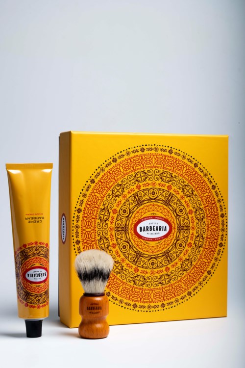 This is a shaving kit with a yellow box, razor, and shaving brush with a wooden handle.