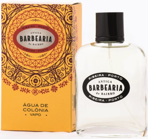 A perfume bottle and box with black and orange designs, labeled 'Antica Barbearia de Bairro' from Ribeira, Porto.