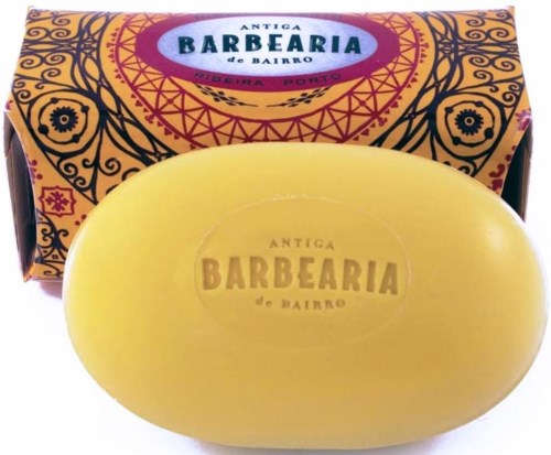 Keltainen saippua, jossa on teksti 'Antiga Barbearia de Bairro', edessä värikäs laatikko.
