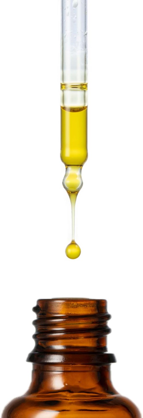 Eine Pipette mit gelber Flüssigkeit über einer braunen Glasflasche.
