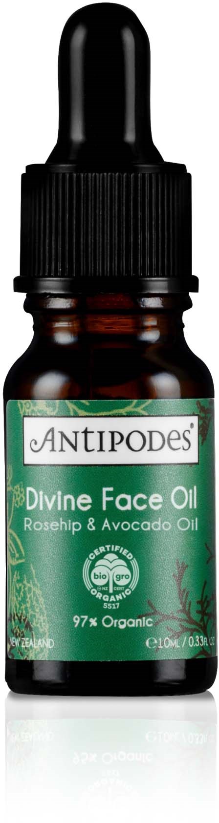 Kleine braune Flasche mit schwarzem Tropfer, beschriftet 'Divine Face Oil' mit Hagebutten- und Avocadoöl, 97% Bio.