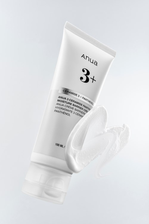Een witte tube huidcrème met wat crème ernaast, op een eenvoudige achtergrond.