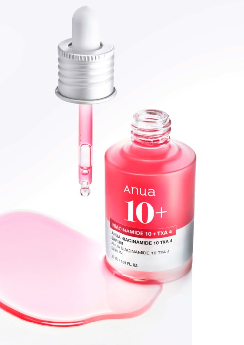 Een roze fles met 'Anua 10+' erop, pipet en een plas roze vloeistof.