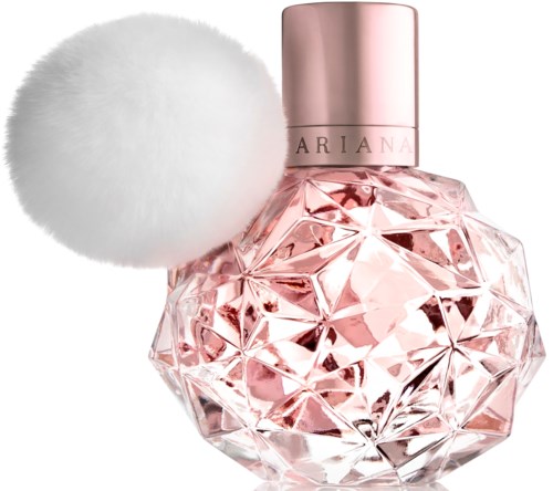 Een roze parfumfles met een grote witte poederkwast ernaast.