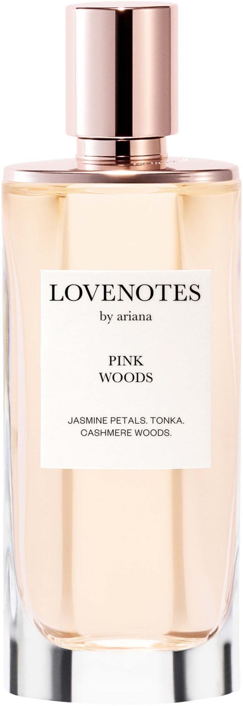 En parfymeflaske med rosa lokk og hvit etikett med tekst Lovonetes by Ariana, Pink Woods duft, jasmin, tonka, kasjmir.