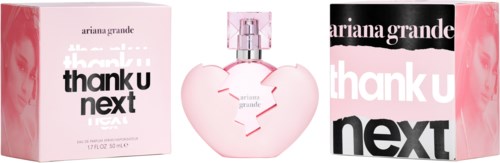 Een parfumfles in de vorm van een gebroken hart, roze met witte details, tussen twee dozen met merknamen.