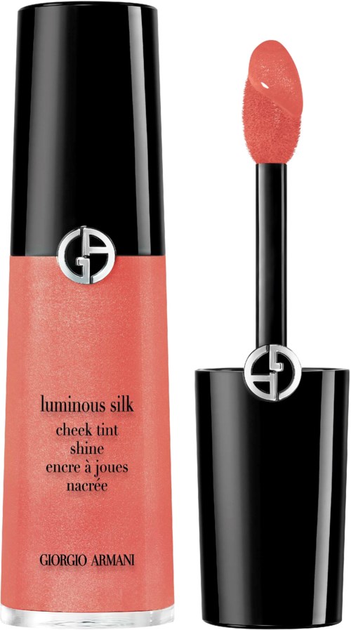 A coral-colored lip gloss with a black cap and a silver logo. The gloss applicator is next to the bottle.