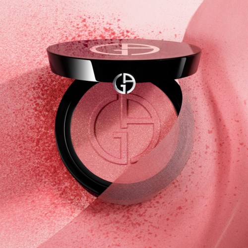 A pink blush compact with a black lid featuring a logo. Blush is partially visible inside.