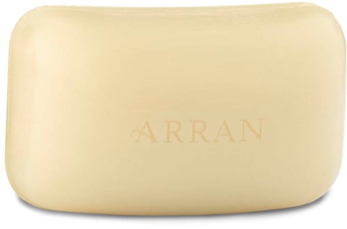 Eine beige Seife mit eingraviertem Wort 'ARRAN', glatte Kanten, rechteckige Form, schlichtes Design.