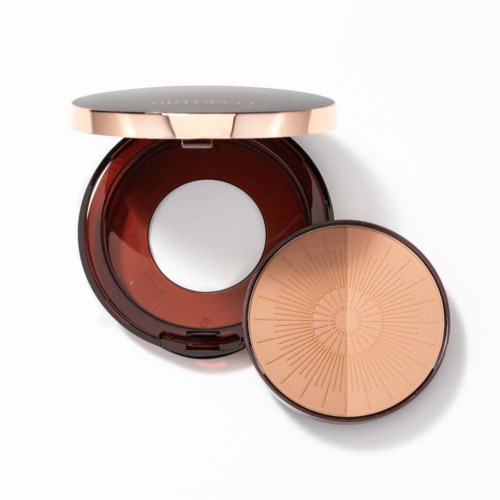 Een compact met twee lagen, één open met spiegel en een ronde container met beige poeder.