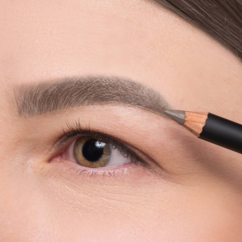 Iemand brengt wenkbrauwmake-up aan met een potloodborstel.