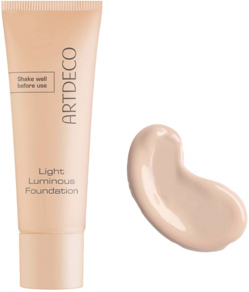 A tube of light luminous foundation with a drop of liquid foundation next to it.