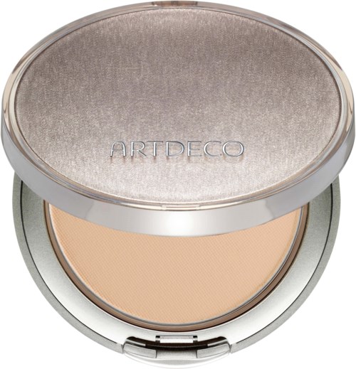 A compact with a shiny top cover and the word 'ARTDECO' engraved, open showing pressed powder inside.